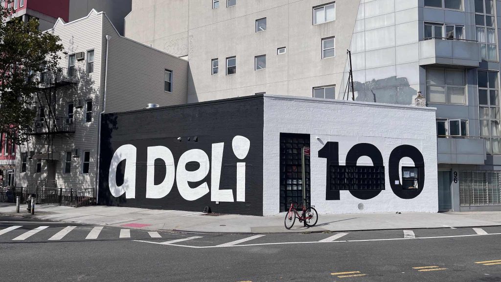 A picture of the Ammazza Deli storefront in East Williamsburg that says A Deli and 100 on the front.